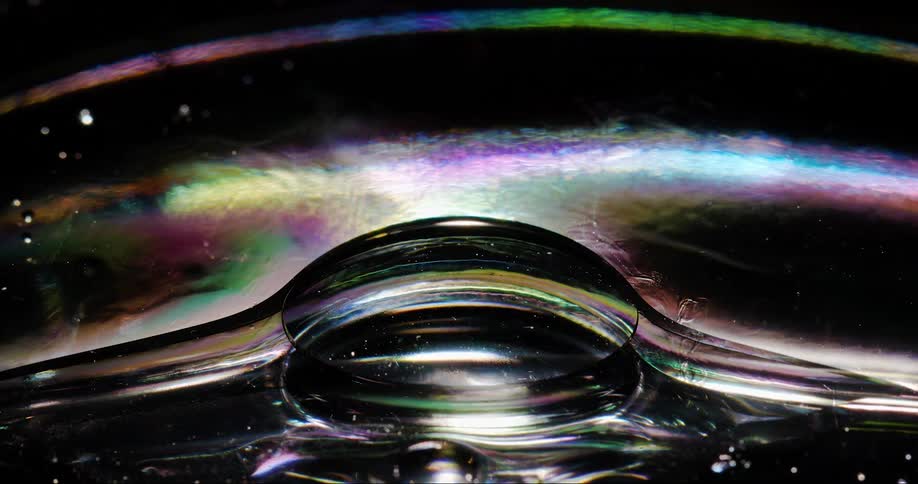 A larger droplet of liquid rises through a more viscous liquid before popping