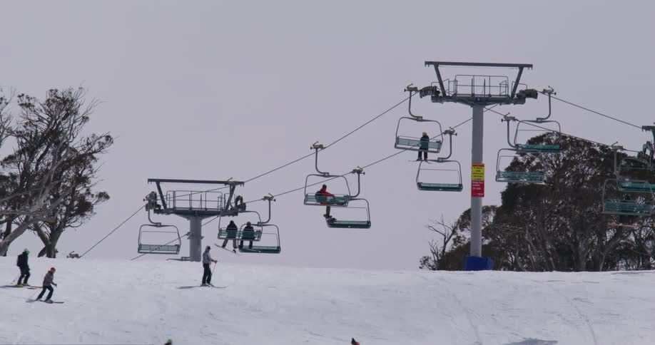 People skiing on a snow slope with cable car
