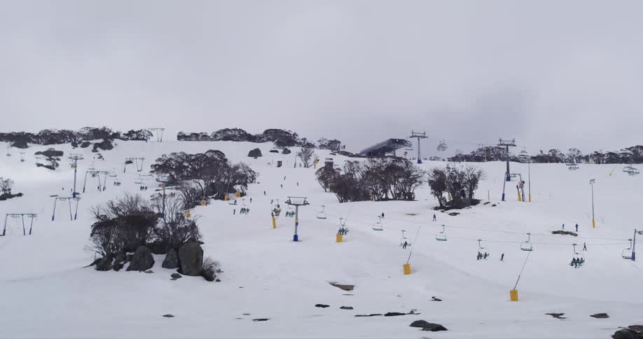 People are riding the ski lifts over the slope