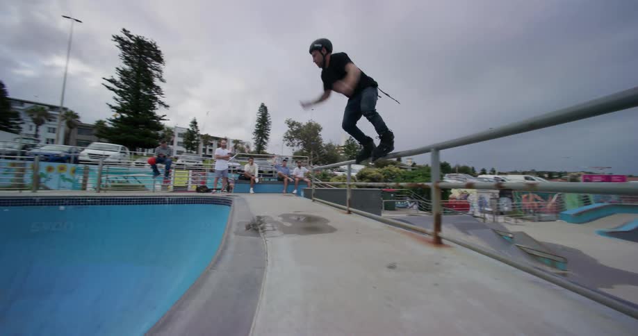 A man jumps into the ramp on his rollerblades