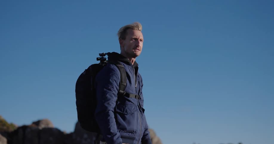 A hiker looks around on a sunny day