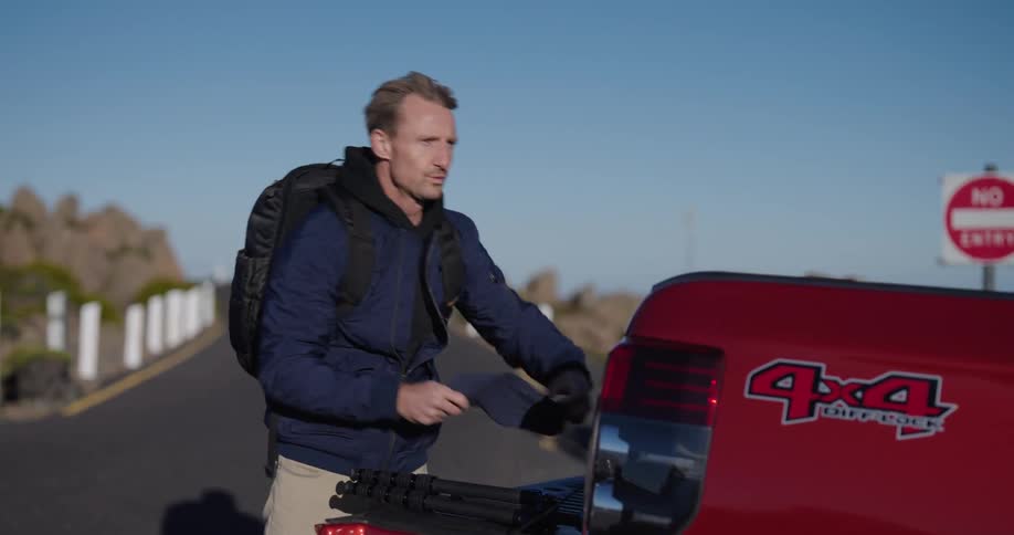 A man takes his backpack from the truck