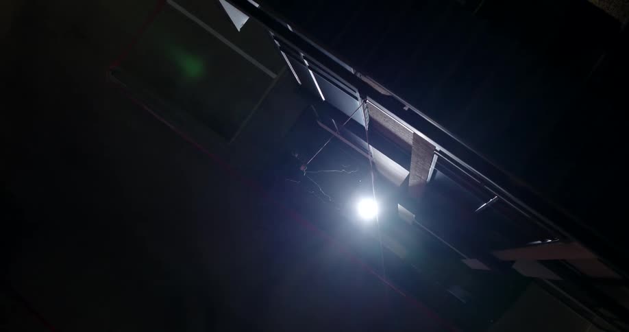 Person on a safety rope at night descending from a building