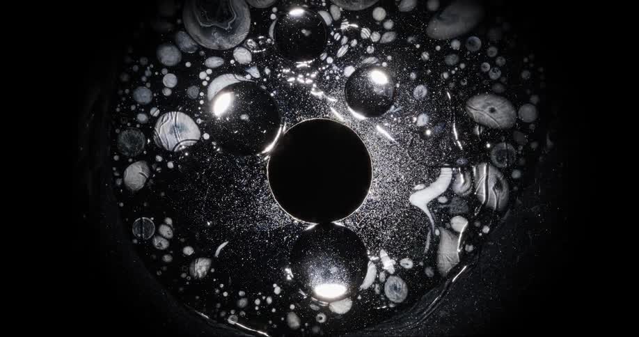Closeup on a glowing liquid dissipating and flowing with bubbles