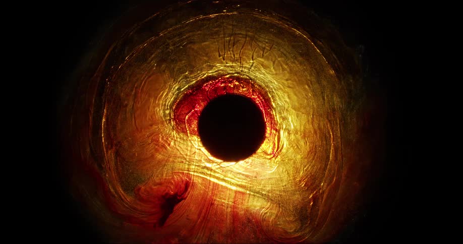 Abstract red orange and yellow liquids ripple around black center circle