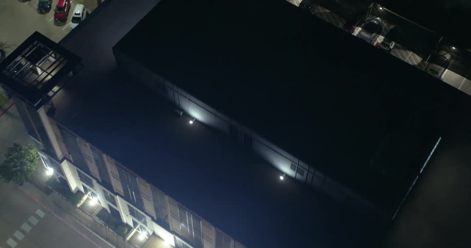 Aerial view of the roof of a building and its parking lot