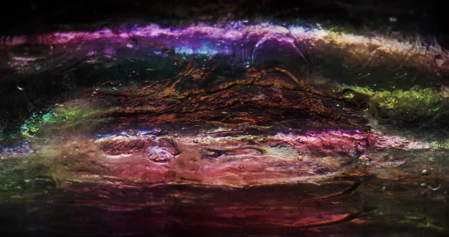 Microscopic view of a colorful and shiny liquid moving abstractly and in slow motion