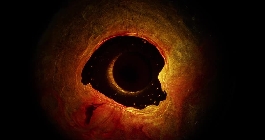 A blob of contracting black liquid surrounded by bright yellowish light