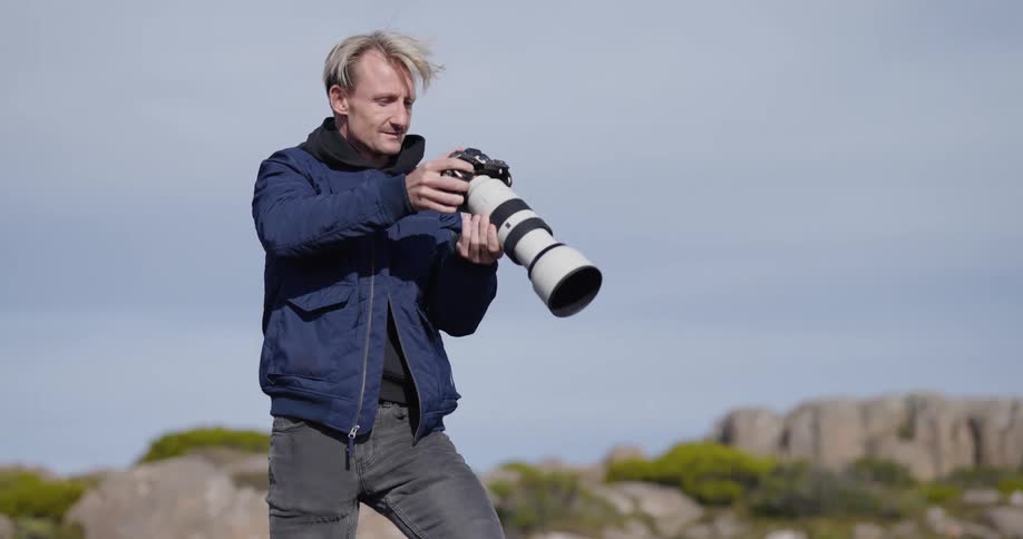 A man photographing the mountainous landscape during the day