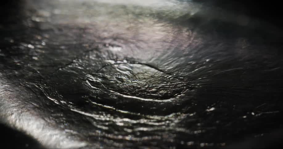 The light reflects on the moving liquid