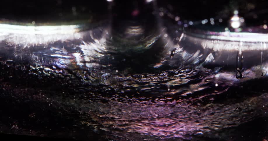Extreme closeup on an abstract transparent liquid expanding by pressure in slow motion