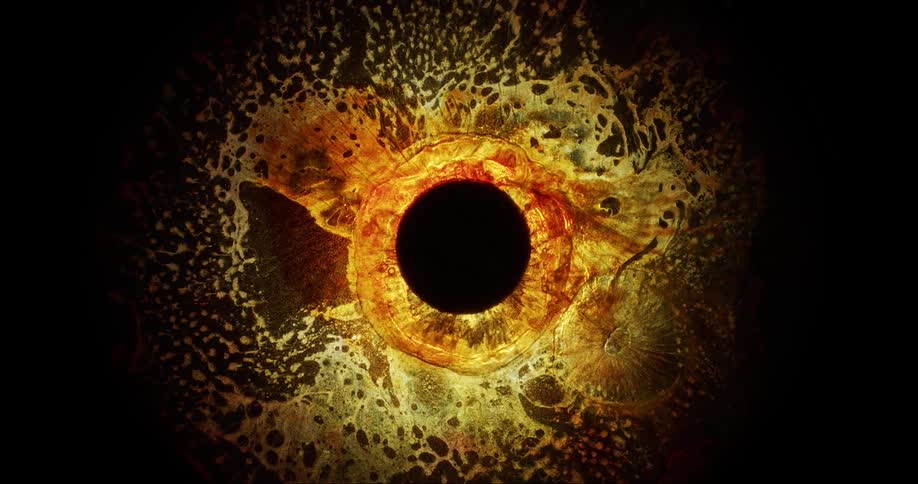 Yellowish shiny liquid on a black background and a suction movement