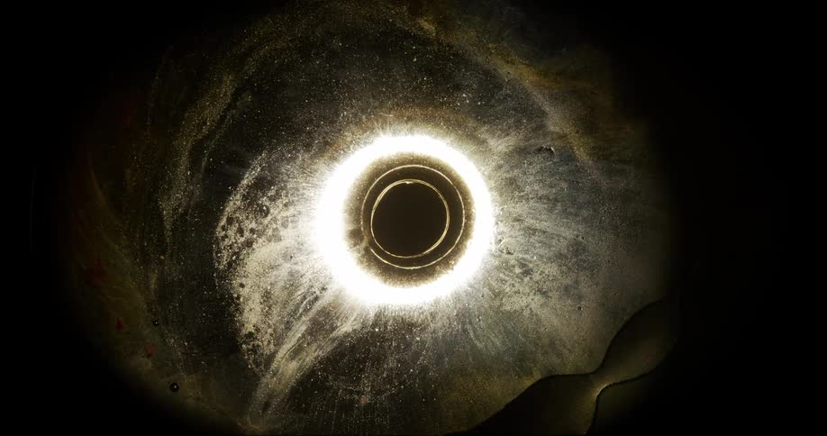Murky layers expand from glowing circles at center of mixture