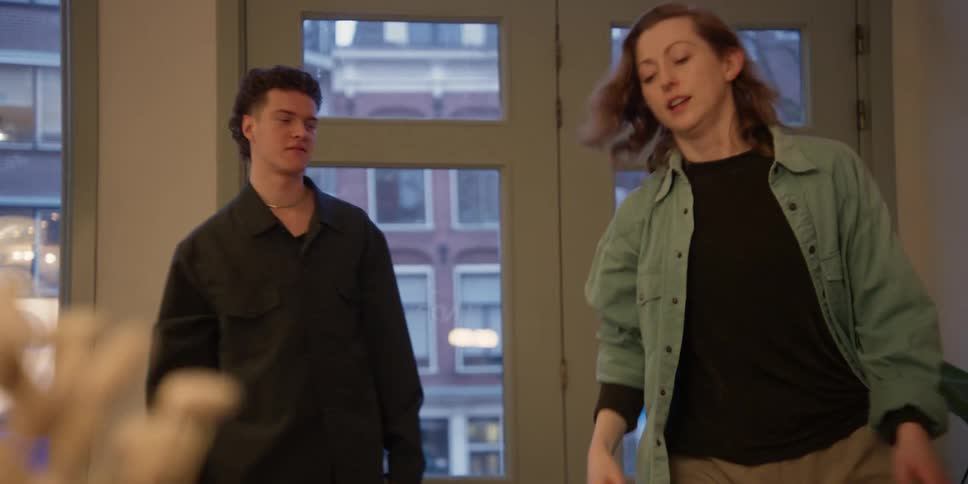 Adult female dance instructor demonstrates and rehearses choreography with her young male student in a private dance studio in the city.