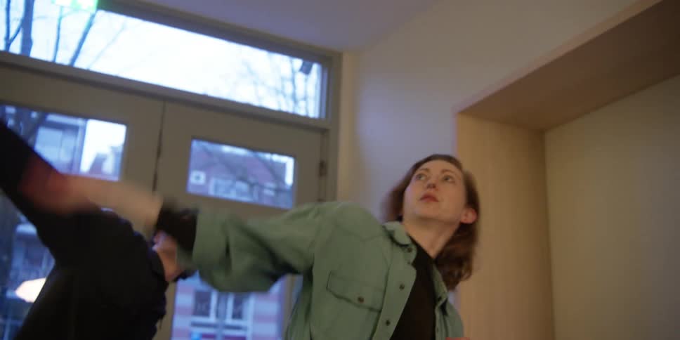 An experienced female dance teacher working on dance choreography and technique with a young male student.