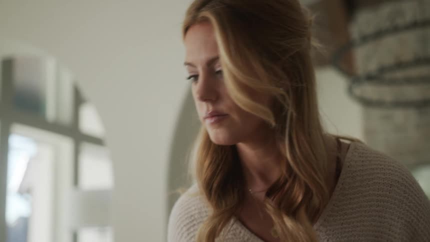 Portrait of a blonde woman indoors during the day looking around concentrated and thoughtful