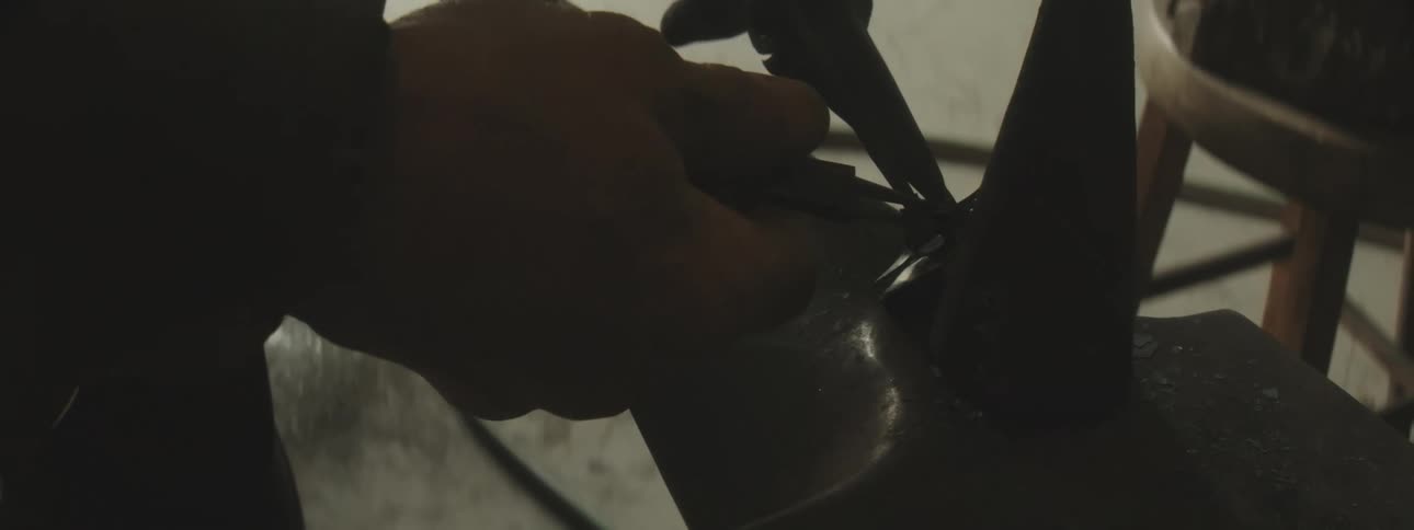 A worker uses tools to tighten a tie
