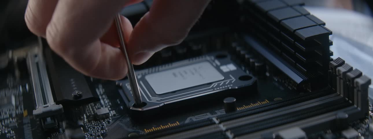 A person screws in a chip on the computer board