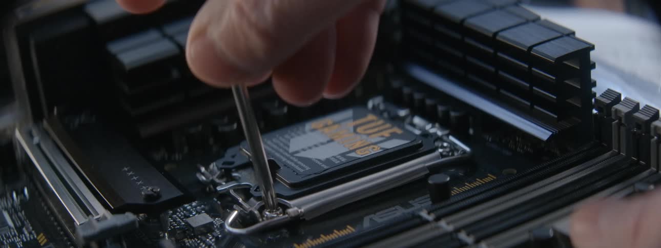 A person screws a chip into the motherboard