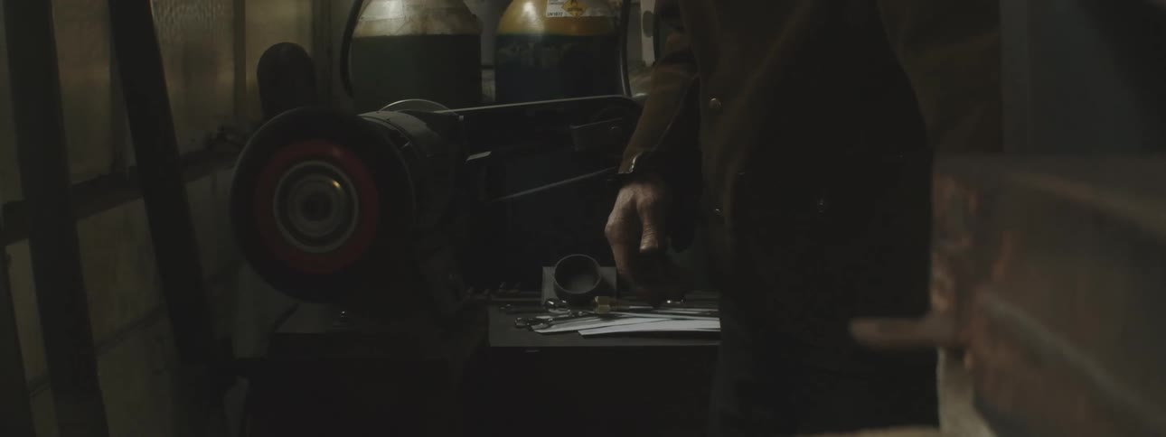 A worker grinds a piece of metal in a shop