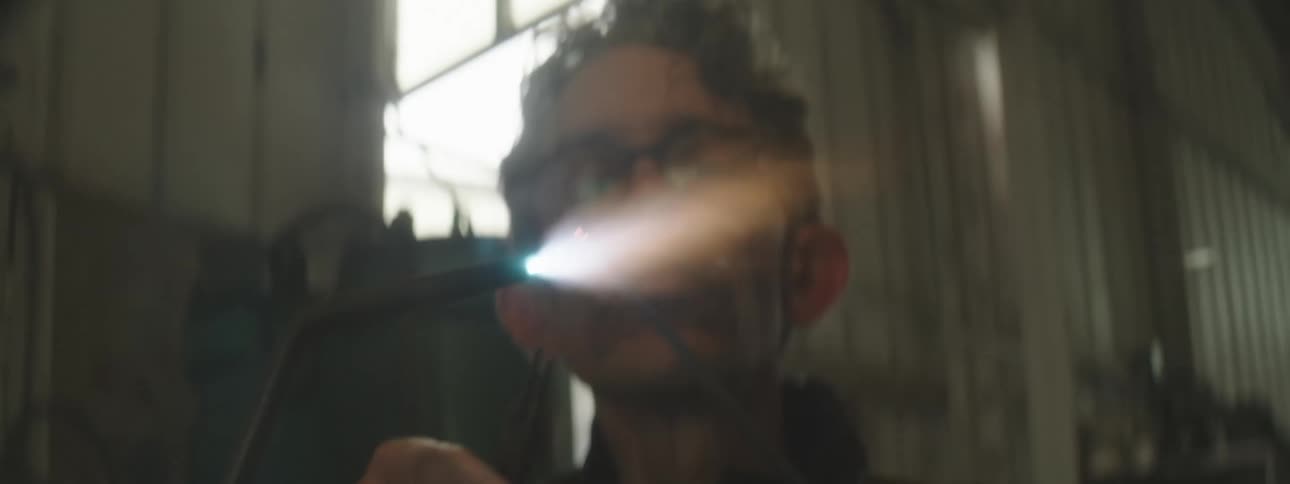 A man holding a high pressure hydrogen torch while wearing glasses