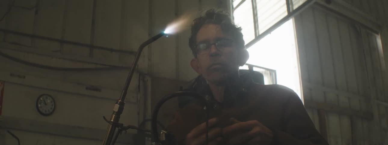A man lights up a welding torch in a workshop