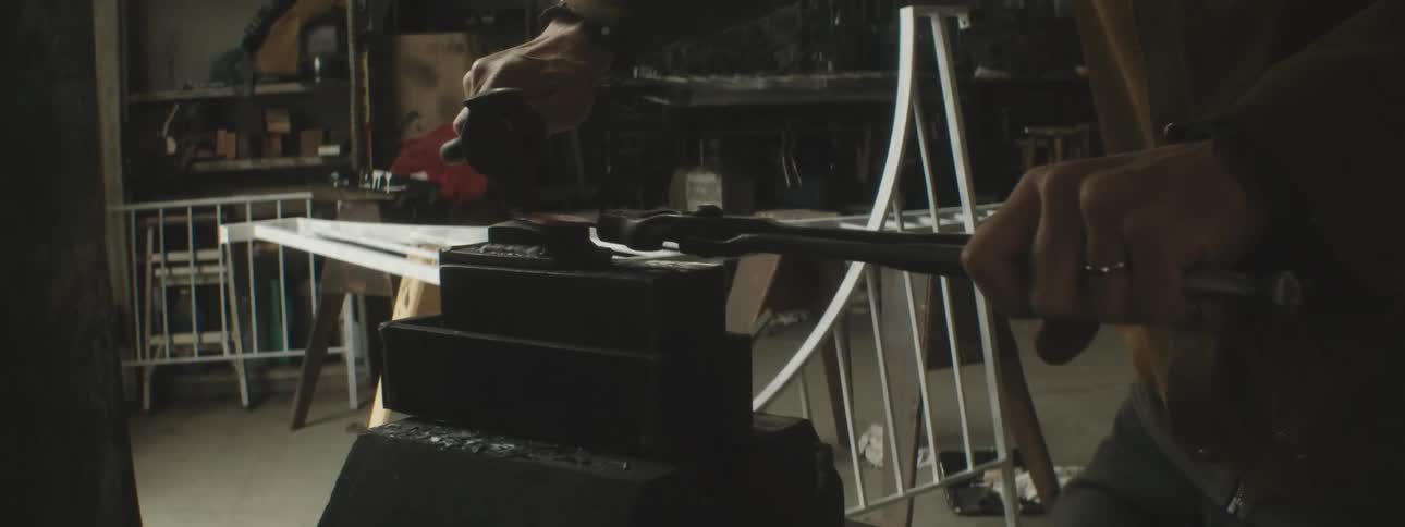 A man is hammering metal on the anvil