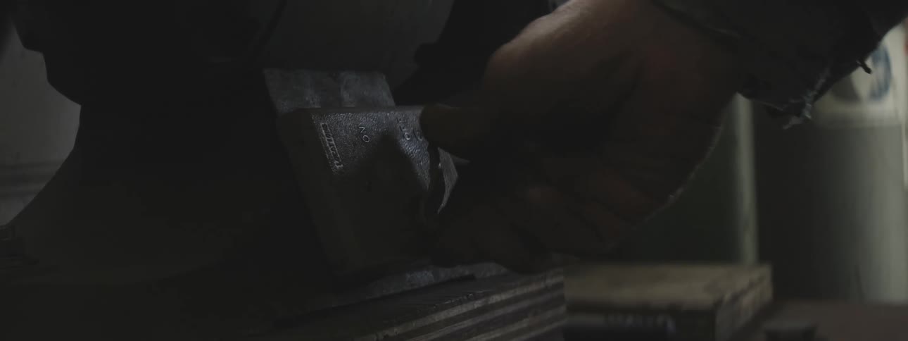 Close in a mans hand turning a pointer of a manual lead machine