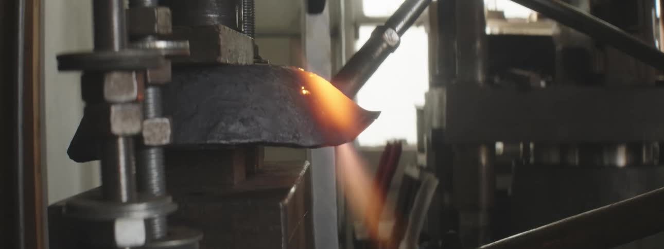Close up of a torch heating up a piece of metal in the workshop
