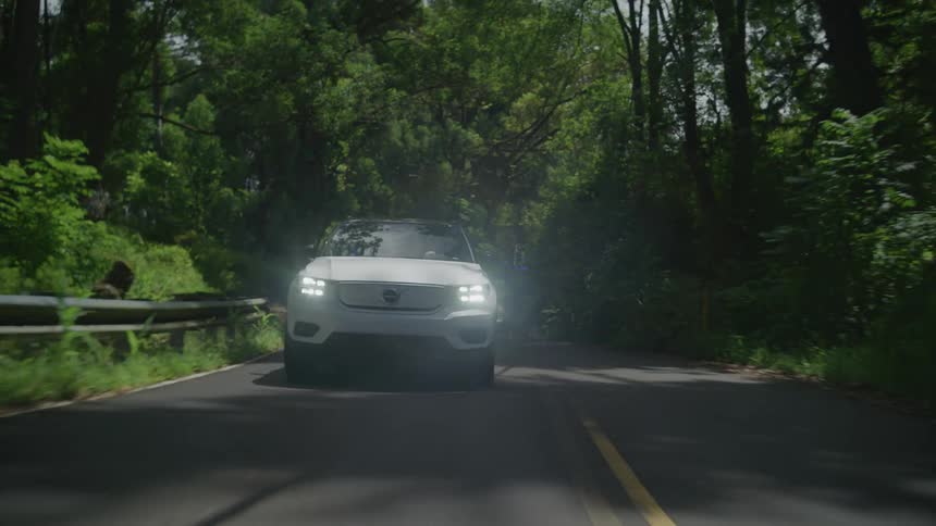 A white car driving in a lonely road during the day