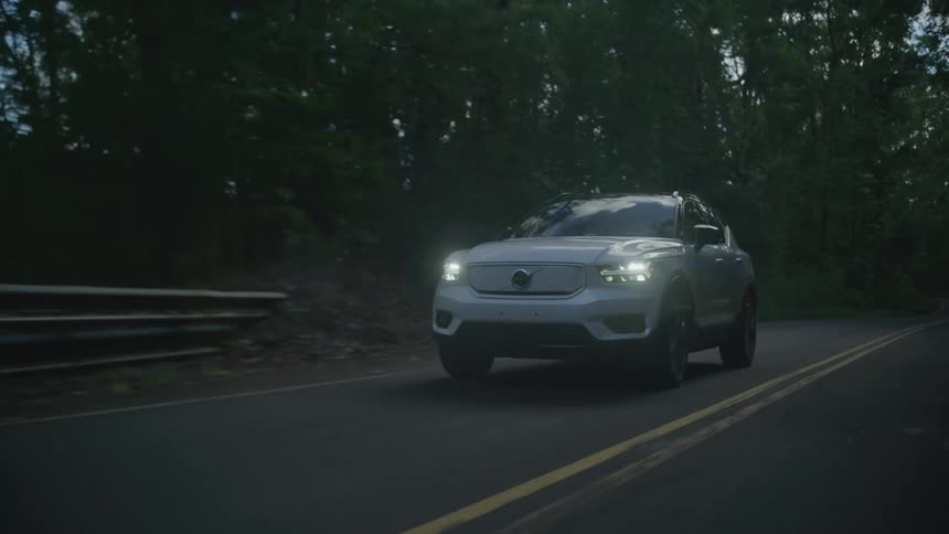 Pearl white suv vehicle walking along the road surrounded by forests