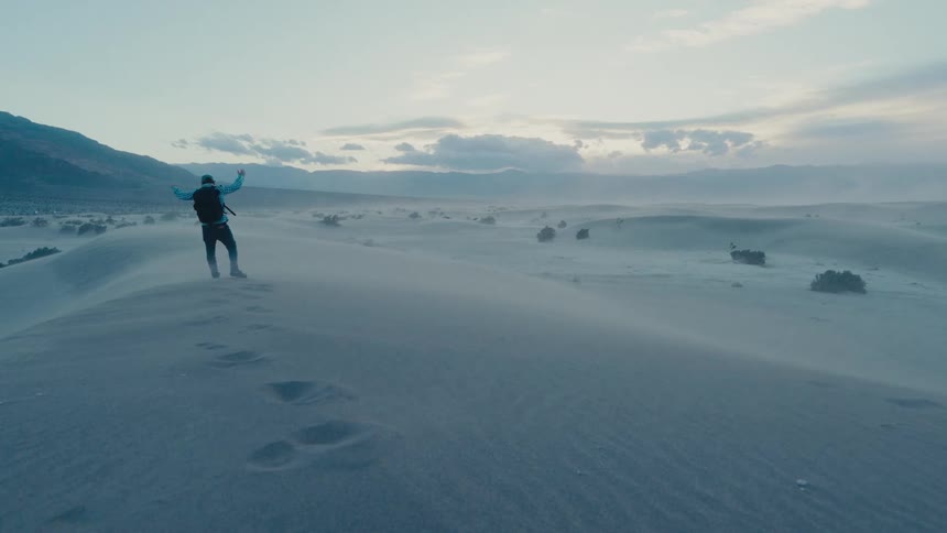 A man is hiking in the dunes of Death Valley National Park