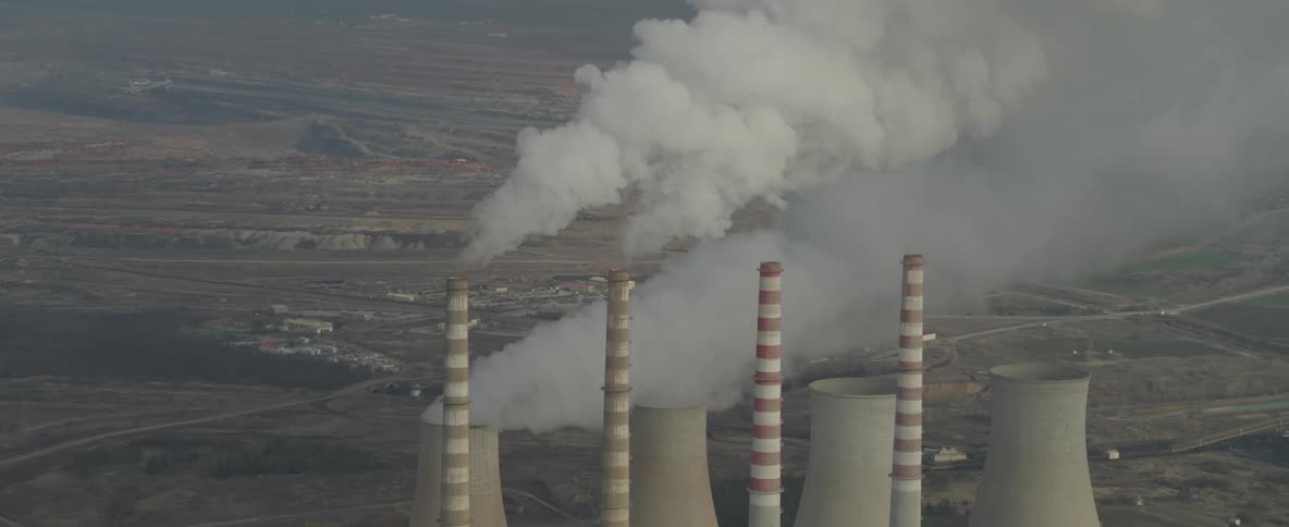 Four industrial towers are releasing a lot of smoke into the sky