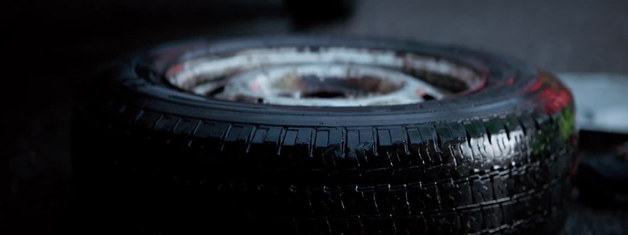 Tire lying on ground near vehicle reflects flashing red light