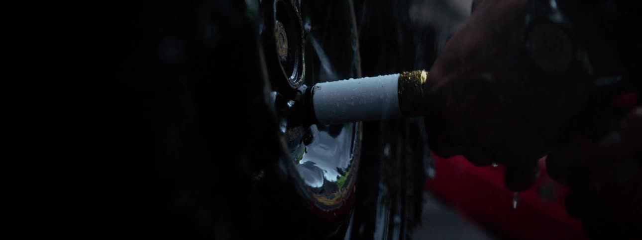 A man unscrews and removes a car tire