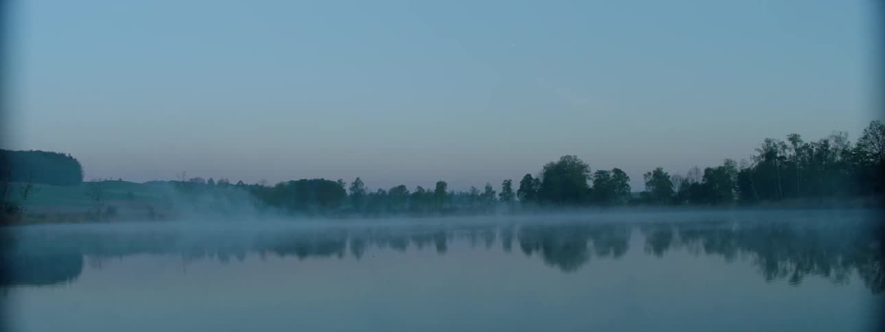 Fog slowly rolling over a lake