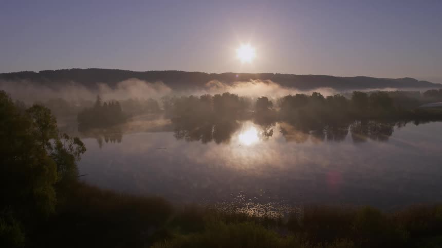 Fog crawling towards a lake
