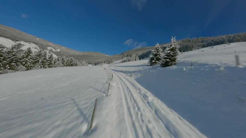 Aerial of snow covered country road and forest against the blue sky