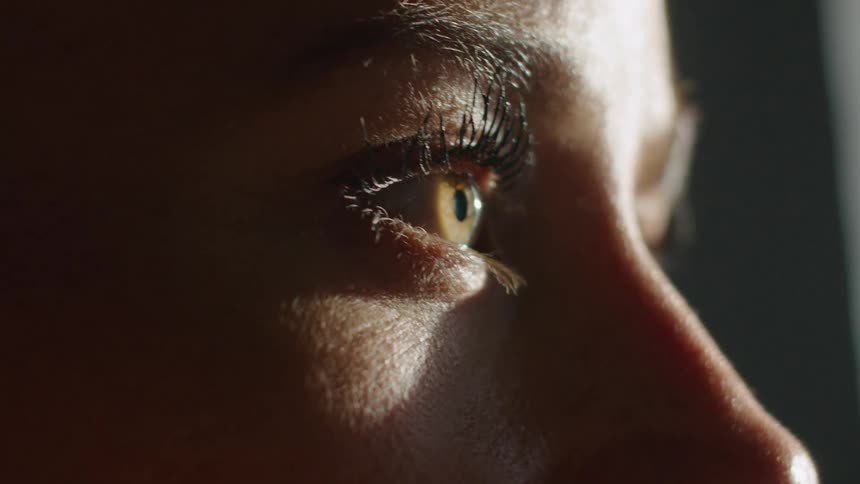 Person looking downward looks up while near window