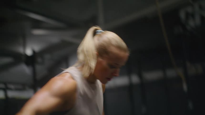 A woman training to jump in a dark gym
