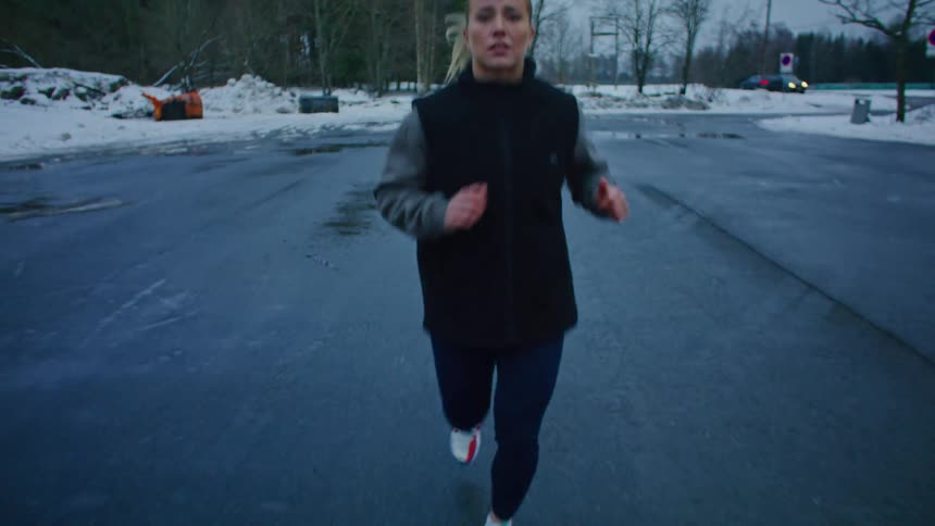 A woman exercising on a deserted street during winter