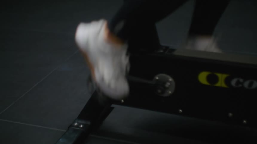Blonde woman pedals on stationary bike in gym