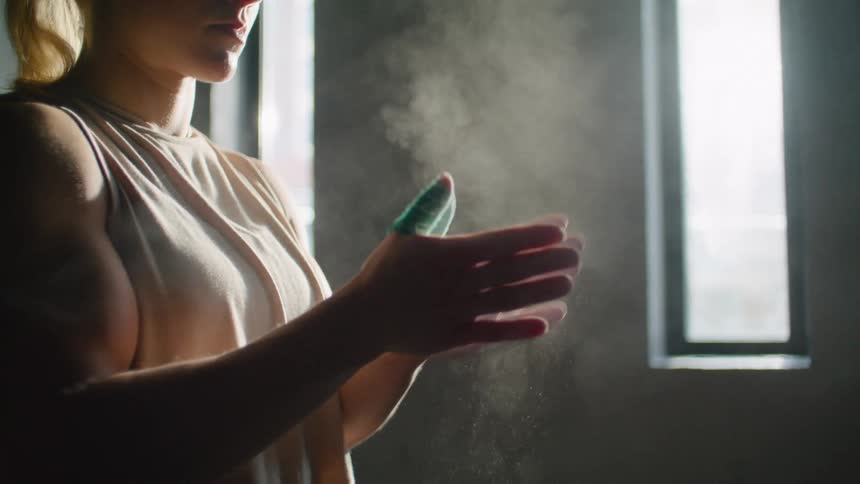 A woman claps her hands to remove excess dust