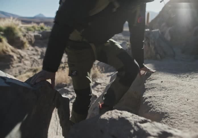 A hiker walks up a rock in the desert