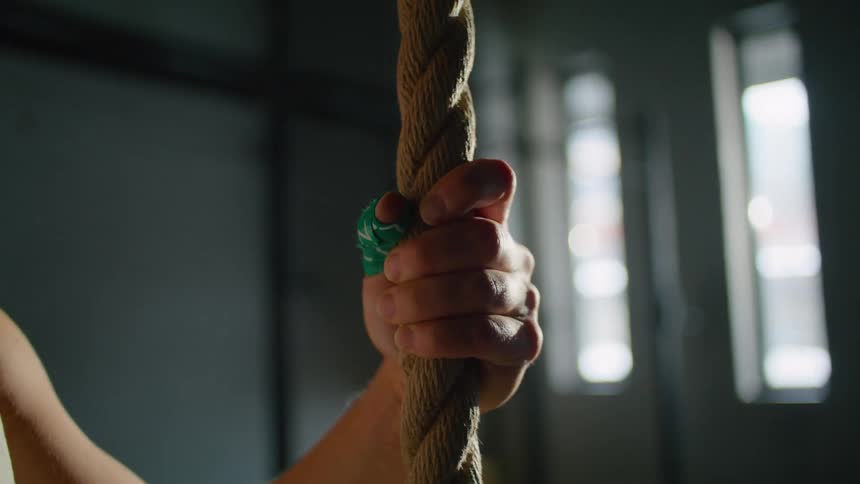 Close up of womans hand holding a rope in the gym