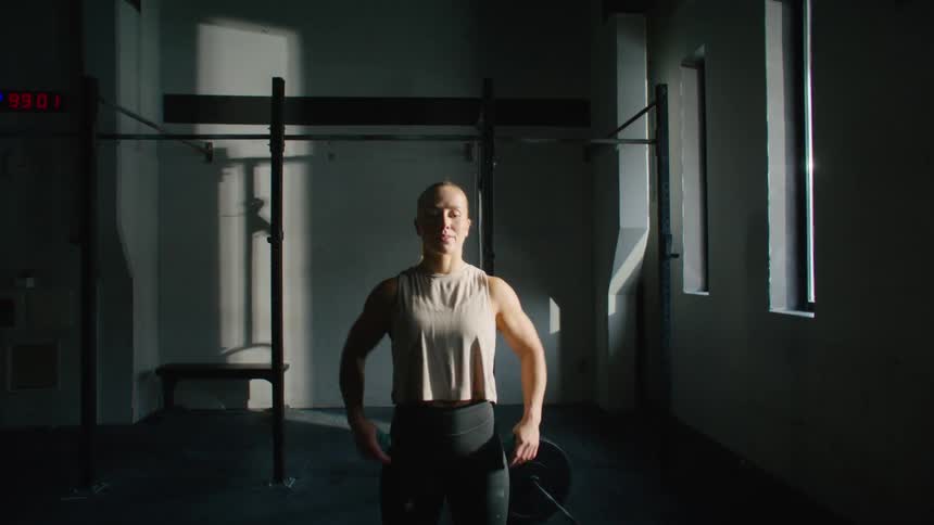 A woman claps her hands in the gym