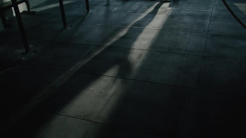 Long shadow moves as person standing in opening swings their arms