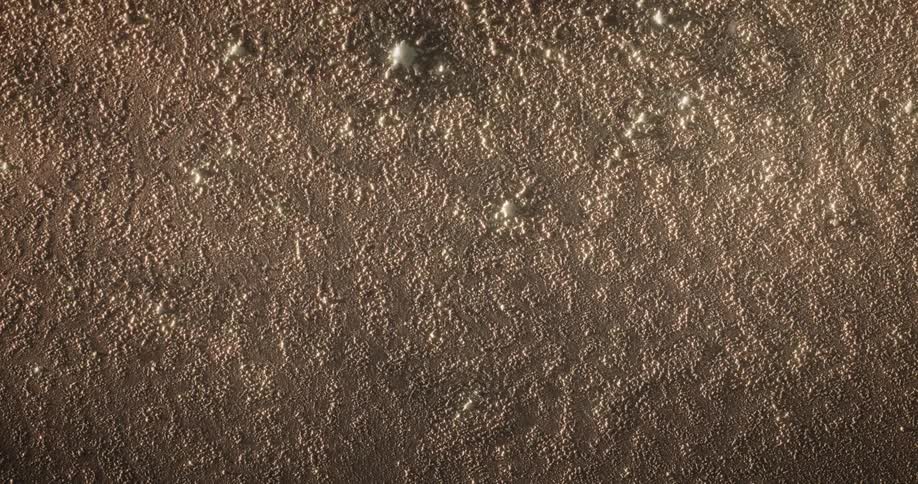 A barren beige surface full of marks and holes