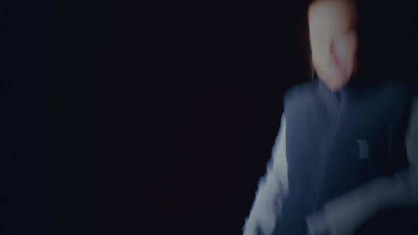 A person in the night walking in the middle of the street