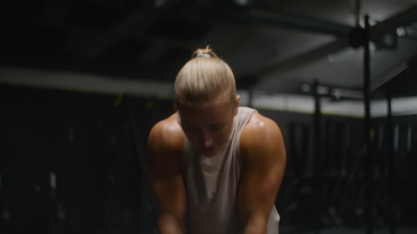 A woman taking a deep breath after working out at the gym